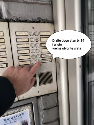 Ruka pritiska dugme stana broj 14 na interfonu za samostalan ulazak u zgradu u Užicu.